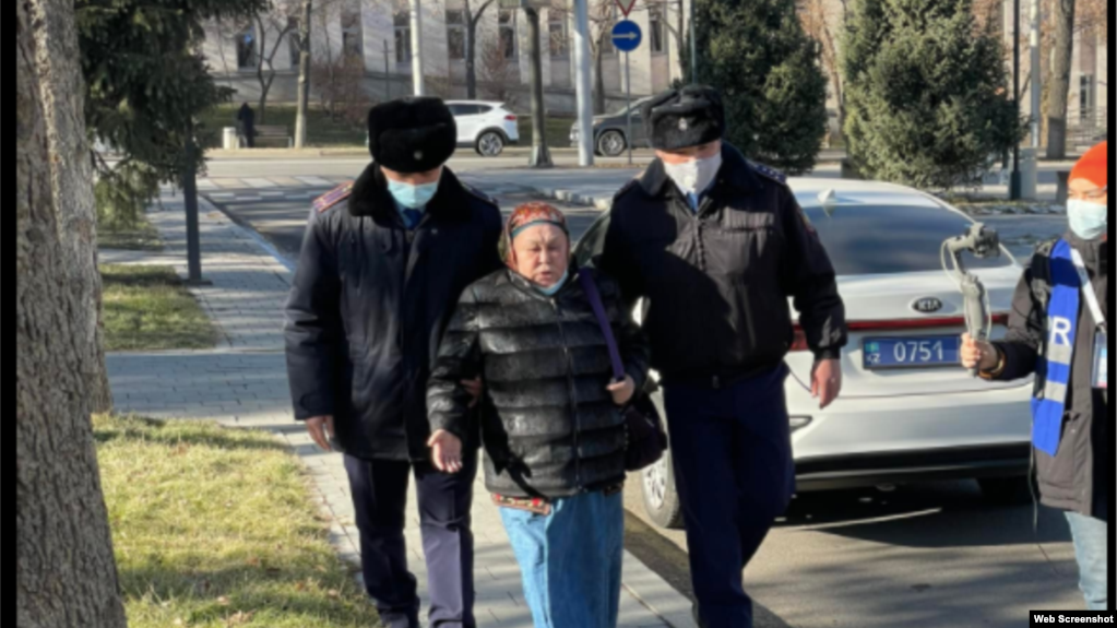 Полицейские ведут к автозаку Халиду Акытхан, которая добивается освобождения из-под стражи троих детей в Синьцяне. Алматы, 2 декабря 2021 года
