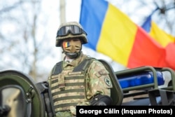 Steagul României, în spatele unui militar care a defilat de Ziua Națională. 1 Decembrie 2021