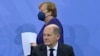 Канцлер Германии Ангела Меркель и ее преемник на посту Олаф Шольц на пресс-конференции после встречи с главами правительств федеральных земель в Берлине, 2 декабря 2021 года