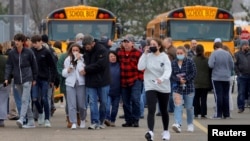 Prindërit duke u larguar me nxënës pas të shtënave me armë zjarri në Miçigen.