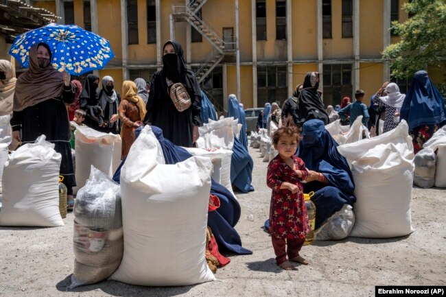 Gratë afgane duke marrë pako ushqimore që i shpërndau një grup i ndihme humanitare, në Kabul, Afganistan, maj 2023.