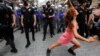 O protestatară dansează în vreme ce poliția încearcă să împiedice activiștii pentru drepturile LGBT să se adune pentru o paradă Gay Pride, interzisă de autoritățile locale, în centrul Istanbulului, Turcia, 26 iunie 2021. 
