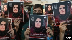 په کراچۍ کې فعالانو د ماهرنګ بلوڅې ګرفتارۍ پرضد د مظاهرې پر مهال په لاسونو کې د هغې تصویرونه نیولي دي - انځور له ارشیفه. 