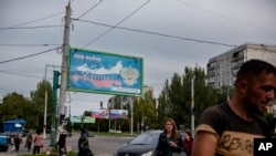 Un panou publicitar pe care scrie: „Alegerea noastră - Rusia” pe o stradă din Luhansk, estul Ucrainei, 22 septembrie 2022