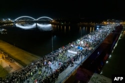 An aerial picture shows demonstrators using the torches of their phones during a 15-minute silence in Novi Sad to commemorate 15 people who died when a roof canopy collapsed in the city's railway station in November, an incident which sparked protests across the country.