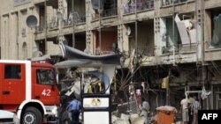 A fire engine arrives at the scene as Iraqi security gather following twin car bombs in the Karrada area of the capital, Baghdad, on July 31.