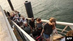 Turiștii îmbarcându-se pentru evacuare în peninsula Cap-Ferret, în sud-vestul Franței, pe 24 iulie 2026.