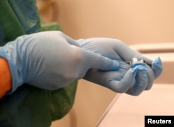 Медсестра собирается ввести вакцину от коронавируса в Латвии. 28 декабря 2020 года