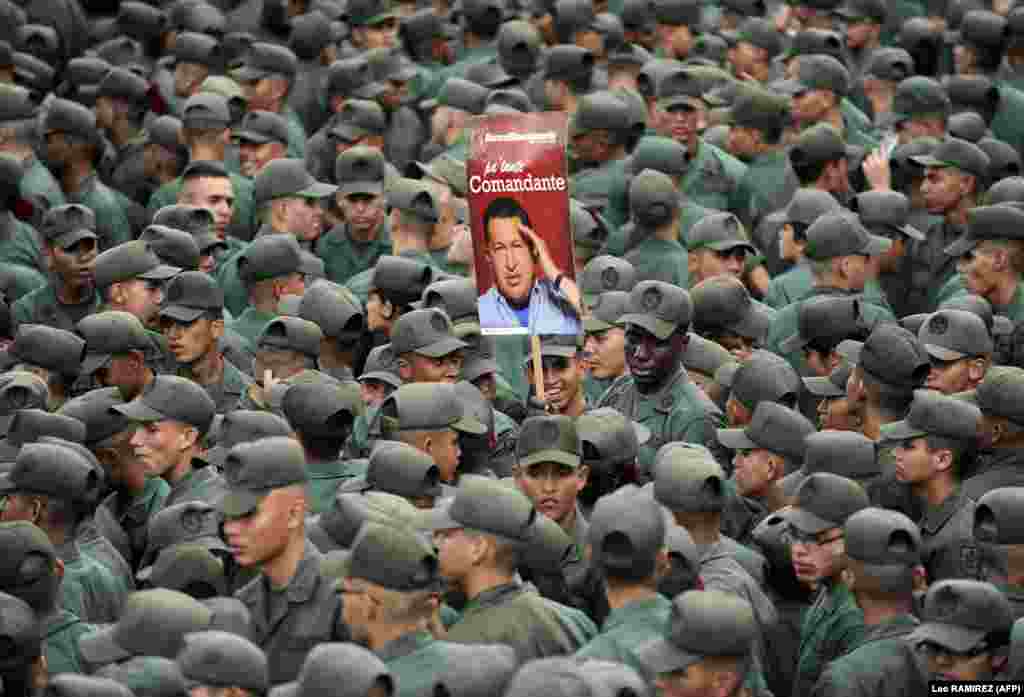 Venezuelan soldiers hold a poster of President Hugo Chavez during a commemoration in Caracas of the failed 1992 coup led by Chavez, who was an army lieutenant colonel, against then-President Carlos Andres Perez. (AFP/Leo Ramirez)