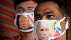Ljudi sa zaštitnim maskama na kojima su američki predsjednik Donald Trump i ruski predsjednik Vladimir Putin u Bhopalu, Indija, 10. juna 2020.