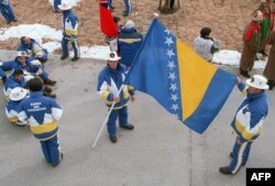 Posljednja zastava BiH, aktuelna i danas, četvrta je zastava BiH po redu i prvi put se pojavila na ZOI u Naganu, 7. februara 1998 (na fotografiji sportisti BiH sa državnom zastavom u Naganu)