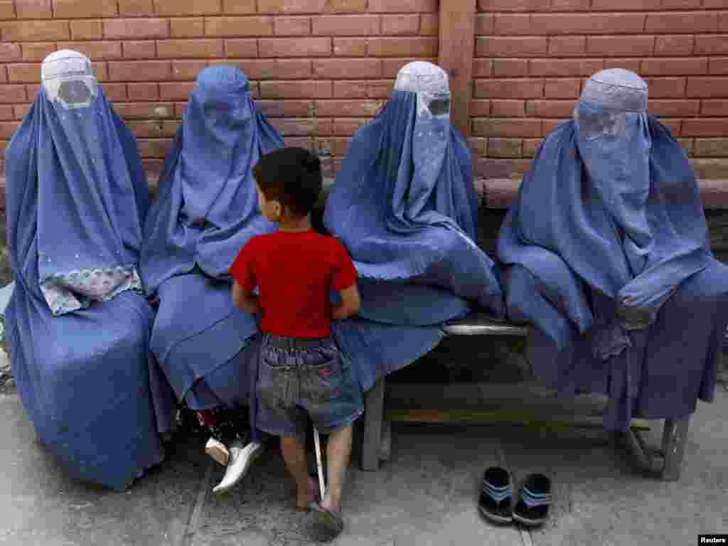 Afghan women and a child wait for transport in Kabul on August 24. Photo by Omar Sobhani for Reuters