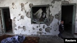 A child walks in a house damaged after heavy shelling by government forces in Sermeen near the northern city of Idlib on February 28.