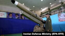Иран қорғаныс министрі Амир Хатами жаңа "Фатих-и Мобин" баллистикалық зымыраны жанында тұр.