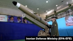 IRAN -- Iranian Defense Minister Amir Hatami stands next to a new generation of Iranian short-range missile 'Fateh-mobin' during an unveiling ceremony in Tehran, August 13, 2018