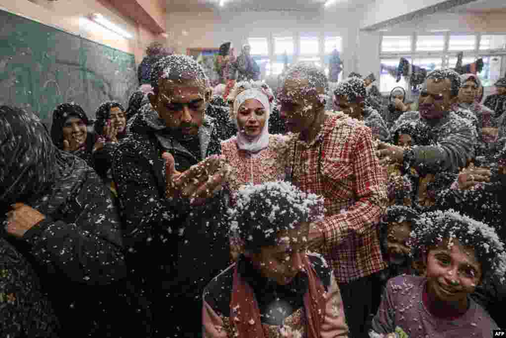 Palestinski mladenci Afnan Jibril i Mustafa Shamlakh, okruženi gostima i rodbinom, na njihovom vjenčanju u učinici škole koju je osnovala&nbsp;Agencija UN-a za palestinske izbeglice (UNRWA) u Rafahu, na jugu Pojasa Gaze, usred neprekidnih borbi između Izraela i militantne grupe Hamas, 12. januara 2024.