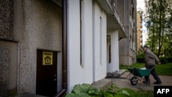 Жоўтая налепка з надпісам Priedanga (Сховішча) ля ўваходу ў падвал, які павінен служыць сховішчам для жыхароў у выпадку небясьпекі ў жылым раёне Фаб’янішкі ў Вільні, 27 траўня 2026 году