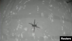 Тази снимка показва сянката на излетелия хеликоптер. Тя първото потвърждение, което получават в НАСА, за това, че полетът е успешен.

