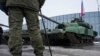 Російський солдат стоїть біля російського танка Т-90 на виставці зброї у Санкт-Петербурзі, Росія, 24 лютого 2024 року