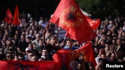 Qytetarë me flamuj të UÇK-së duke pritur shpalljen e aktgjykimit ndaj katërshes së UÇK-së. Prishtinë, 16 shtator 2026.