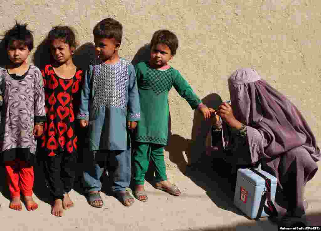 An Afghan health worker marks the little finger of a child after administering a polio vaccination to children in Kandahar. (epa-EFE/Muhammad Sadiq)