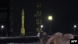 Верблюд рядом с российской ракетой со спутником Turksat-4A на старте на космодроме Байконур. 15 февраля 2014 года