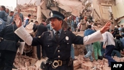 An Argentinian policeman prevents people from approaching the site where a powerful explosion destroyed the seven-story building housing the Jewish Mutual Association of Argentina in Buenos Aires in July 1994.