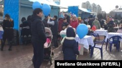 Граждане рядом с синими воздушными шарами на площади во время праздничных мероприятий по случаю Наурыза. Астана, 22 марта 2018 года.