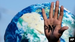 Në dorën e një aktivisti është shkruar "paguaj", duke bërë thirrje për themelimin e fondit për humbje dhe dëme në Samitin e OKB-së për klimën, COP27, më 18 nëntor, 2022, në Egjipt.