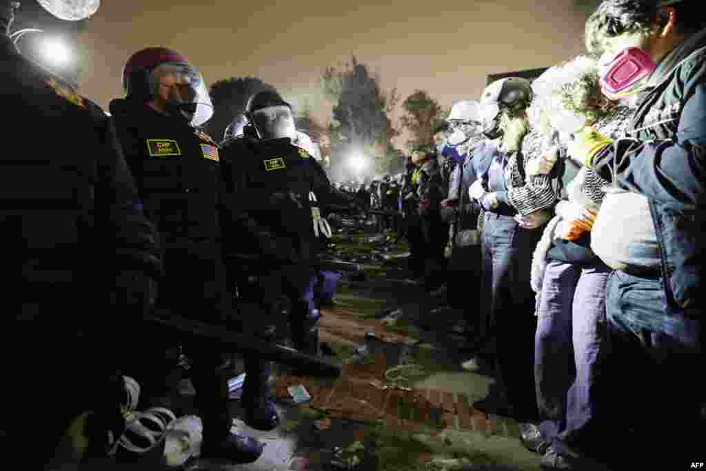 Polițiștii din Los Angeles, față în față cu demonstranții pro-palestinieni, la Universitatea Californiei din Los Angeles (UCLA), după ce forțele de ordine au distrus o parte din tabăra protestatarilor. Studenții au scandat și după aceea &bdquo;Nu ne e frică!&rdquo;.