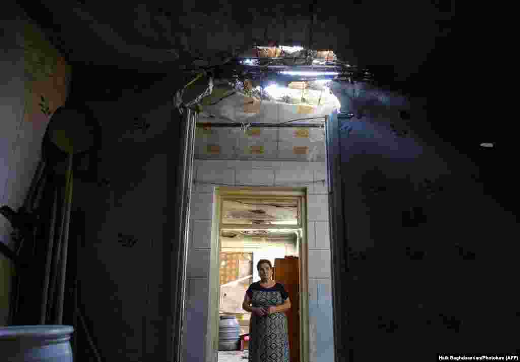 A woman and her damaged home in the Armenian village of Aygepar