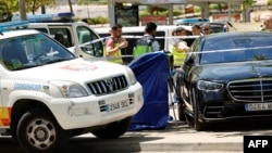 Spanish police officers work near the body (behind blue curtain) of late ex-Ukraine MP Andriy Portnov, after he was shot dead near Madrid on May 21.