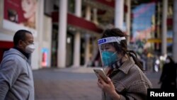 Egy nő maszkban és védőszemüvegben Sanghajban 2023. január 3-án