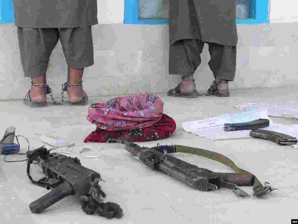 Afghan police show off two suspected militants to the media in Kandahar. The two were arrested during a security operation; arms and bomb-making materials were allegedly in their posession. Photo by Humayoun Shiab (epa)