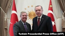 Turkish President Recep Tayyip Erdogan (R) shakes hands with U.S. Senator Lindsey Graham (L) as they pose for a photo at Presidential Complex in Ankara, January 18, 2019