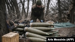  Украински боен приготвя за изстрелване 155-милиметрови снаряди покрай Бахмут, Украйна, през март 2023 година 