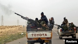 Libya -- A rebel fighter fires his anti-aircraft gun as he flees together with other rebel fighters from Ajdabiyah, outside Ajdabiyah on the road to Benghazi, 15Mar2011