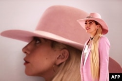  Лейди Гага театралничи пред обложката на албумa си Joanne в Токио, Япония, през 2016 година 