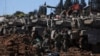 Israeli soldiers gather next to military vehicles on the Israeli side of the border with Lebanon in northern Israel on March 17.