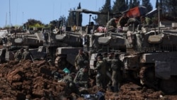 Israeli soldiers gather next to military vehicles on the Israeli side of the border with Lebanon in northern Israel on March 17.