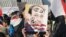 Sunni protesters hold up a defaced portrait of Iraqi Prime Minister Nuri al-Maliki at a rally in Ramadi in January 2013.