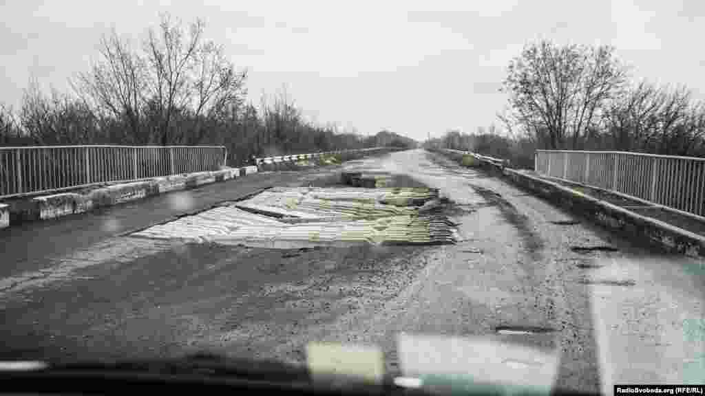 Дорога до міста Попасна всіяна &laquo;свідченнями&raquo; війни. Один із прикладів &ndash; цей зруйнований міст. Пасажири автобусів, що їздять цією дорогою, пішки проходять небезпечне місце і тільки після цього повертаються в салон