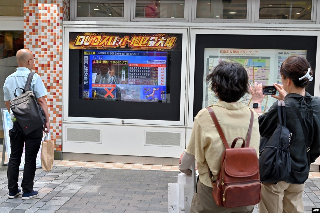 Kalimtarë në Tokio ndjekin lajmet pas paralajmërimit për cunam, në Japoni, më 30 korrik 2025.