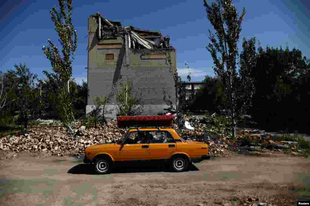 A&nbsp; Ukrainian man drives away from his house in Toretsk on August 22 after it was destroyed by shelling.&nbsp;