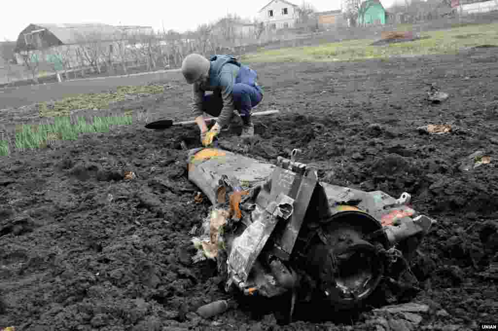 Сапер роздивляється уламок, що опинився на городі внаслідок вибухів на складах зберігання боєприпасів поблизу міста Балаклія, Харківська область, 24 березня 2017 року БІЛЬШЕ ПРО ЦЕ