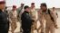 A handout picture released by the Iraqi premier's press office shows Prime Minister Haidar al-Abadi (center) shaking hands with army officers upon his arrival in Mosul on July 9.