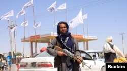 Бойовик «Талібану» під прапорами свого руху. Фото з міста Газні, центру однойменного вілаяту (провінції), 15 серпня 2021 року