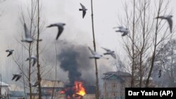 Flames and smoke billow from a residential building where militants are suspected to have taken refuge during a gun battle in Pulwama, south of Srinagar in Indian-controlled Kashmir on February 18.