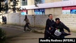 A man is stopped while trying to raise the black flag of the Islamic State group at an opposition rally in Baku in October. Baku has attempted to crack down on citizens joining militant groups.