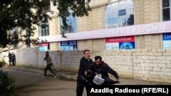 A man tries to raise the black flag of Islamic State militants at an opposition rally in Baku on October 12.